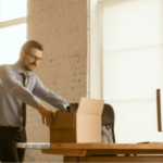 un impiegato riempie uno scatolone in un ufficio
